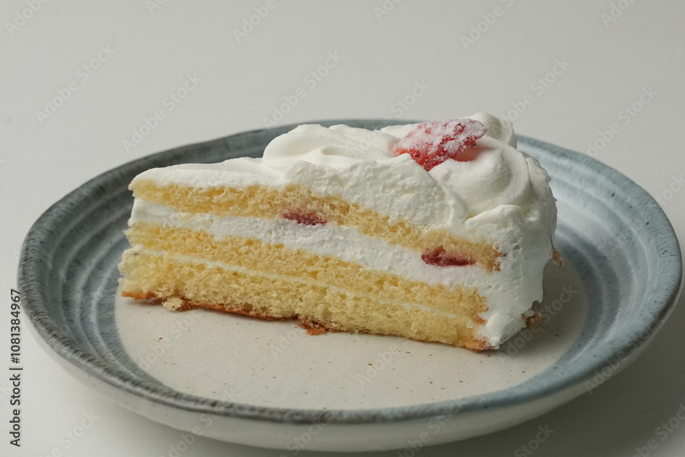 One small Japanese strawberry shortcake on a stylish Japanese plate on a white table One small Japanese strawberry shortcake on a stylish Japanese plate on a white table