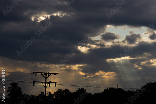 Sky with clouds and electricity pole at sunset