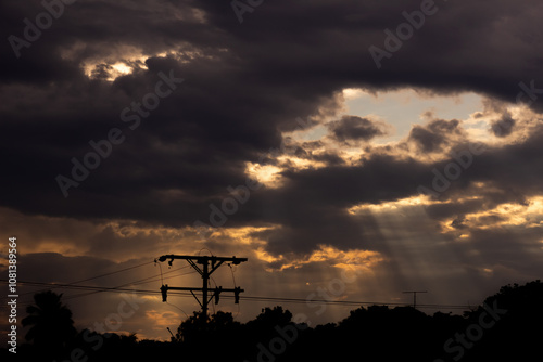 Sky with clouds and electricity pole at sunset