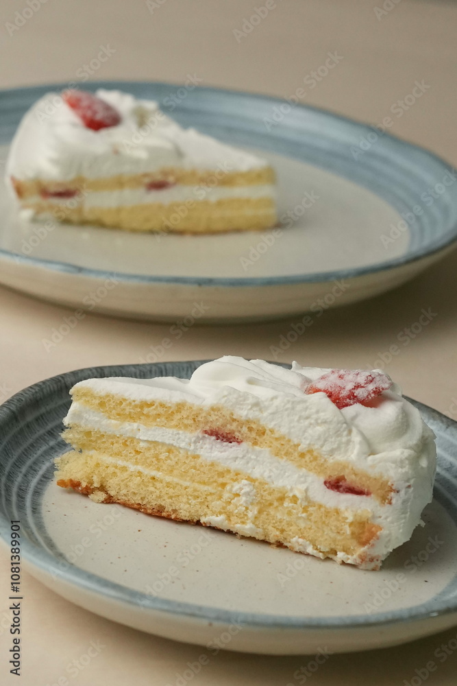 Japanese strawberry shortcake on each stylish large and small plate on a wooden table Japanese strawberry shortcake on each stylish large and small plate on a wooden table