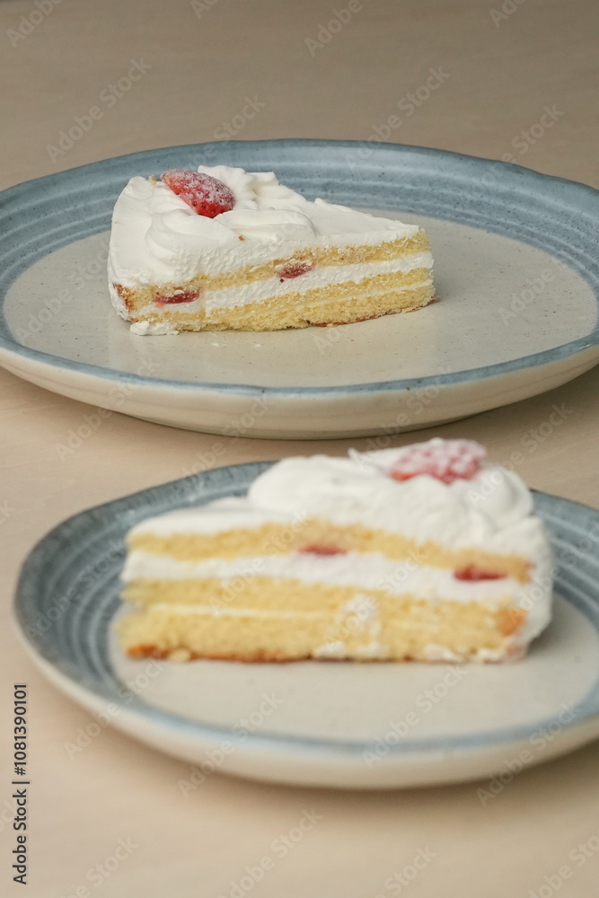 Japanese strawberry shortcake on each stylish large and small plate on a wooden table Japanese strawberry shortcake on each stylish large and small plate on a wooden table