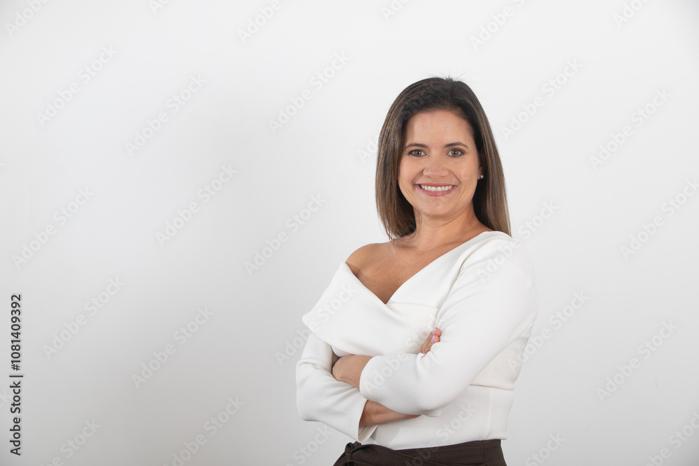 Smiling confident woman with arms crossed, wearing an elegant white blouse and brown trousers, isolated on white background, representing empowerment, professionalism, leadership and business Style Smiling confident woman with arms crossed, wearing an elegant white blouse and brown trousers, isolated on white background, representing empowerment, professionalism, leadership and business Style