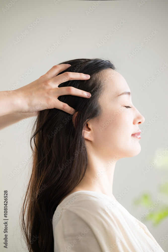Naklejka premium Close-up of an image of a head massage or head massage with eyes closed Vertical