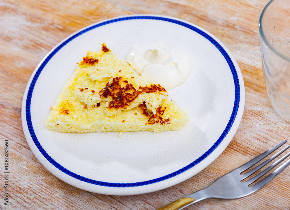 There is piece of casserole on plate, made from cottage cheese, sugar and vanilla. Traditional sweet diet snack, Russian cuisine There is piece of casserole on plate, made from cottage cheese, sugar and vanilla. Traditional sweet diet snack, Russian cuisine