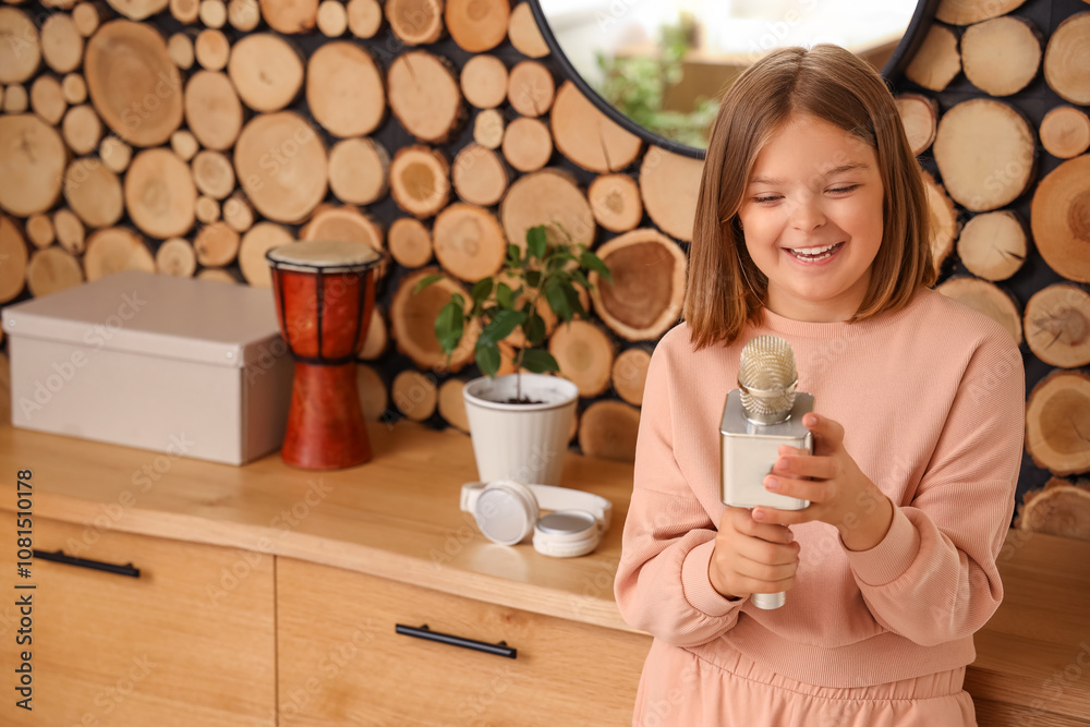 Cute little girl with modern microphone at home Cute little girl with modern microphone at home