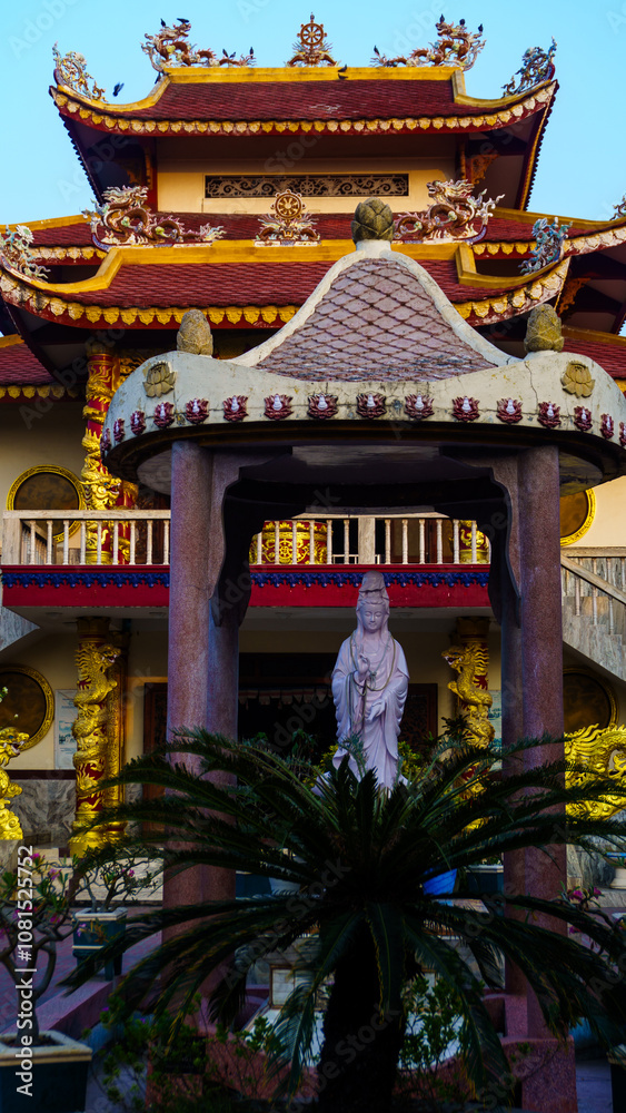 Serene Temple Courtyard with Buddha Statue and Ornate Roof