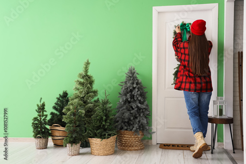 Young woman decorating door...
