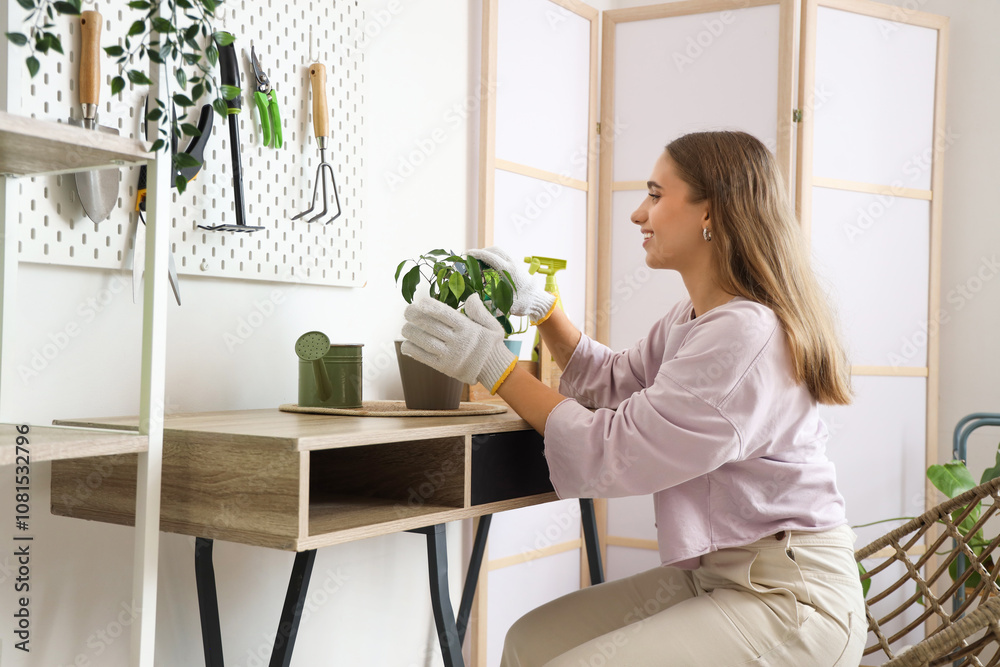 Female gardener with plant sitting at table in workshop Female gardener with plant sitting at table in workshop