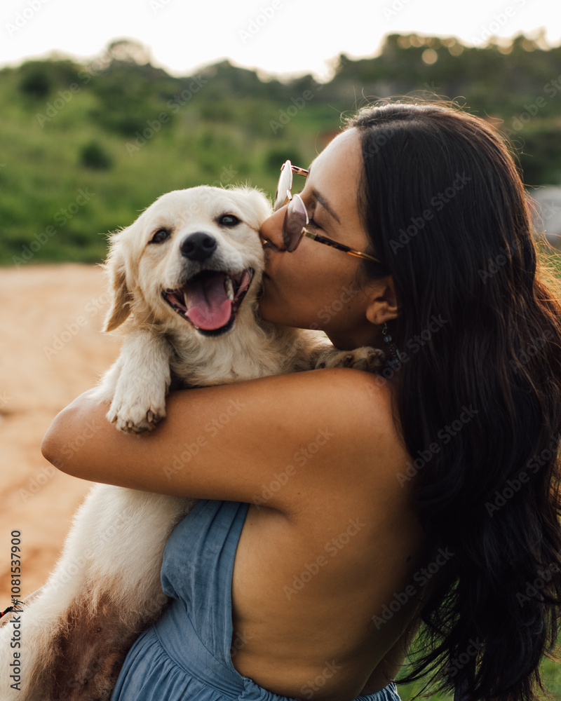 Plano medio de mujer con lentes abrazando, cargando, besando y dando amor a su perro mascota al aire libre. Plano medio de mujer con lentes abrazando, cargando, besando y dando amor a su perro mascota al aire libre.