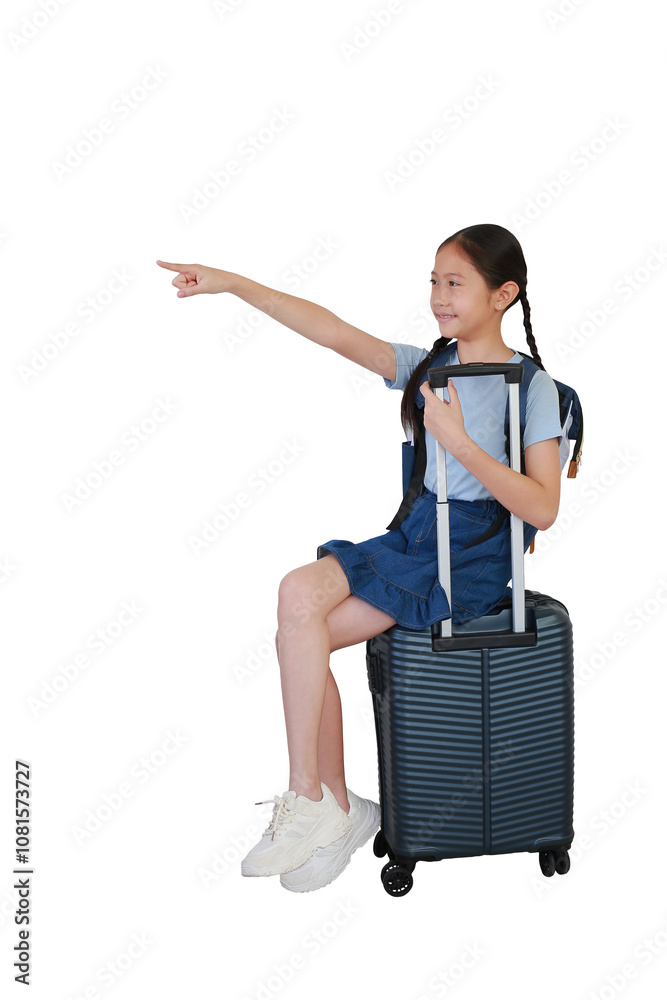 Asian girl child sitting on suitcase with point and looking beside on empty space isolated on white background. Kid fashion and travel concept. Full body photo with clipping path. Asian girl child sitting on suitcase with point and looking beside on empty space isolated on white background. Kid fashion and travel concept. Full body photo with clipping path.