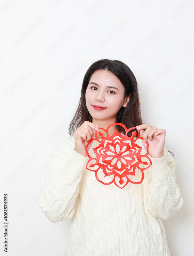 A Chinese woman putting up window decorations at home on the theme of Spring Festival A Chinese woman putting up window decorations at home on the theme of Spring Festival