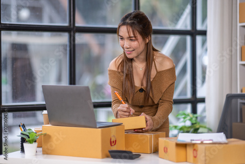 Startup girl Small SME business owners work with laptop computers at work. with parcel paper boxes for delivery to customers online selling, Ecommerce, 