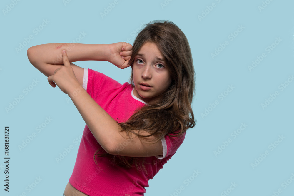 Girl points to scrape on arm with concerned expression. Girl points to scrape on arm with concerned expression.