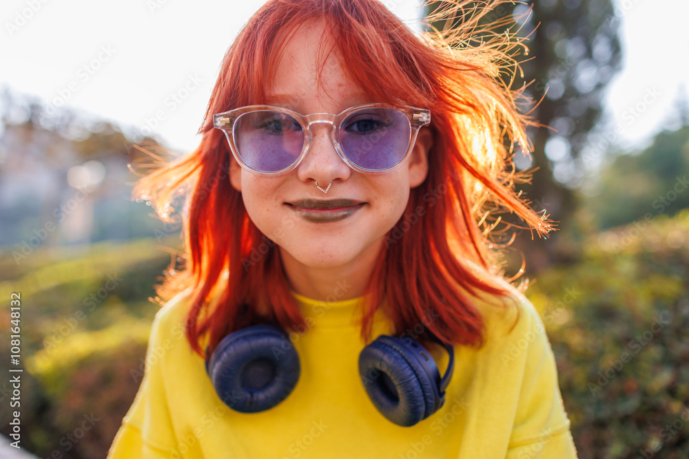 Young beautiful smiling girl with piercing on her face in fashionable clothes. Carefree woman smiling on the street on a sunny day.