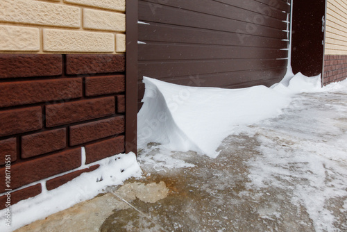 A brick wall with a snow covered garage door