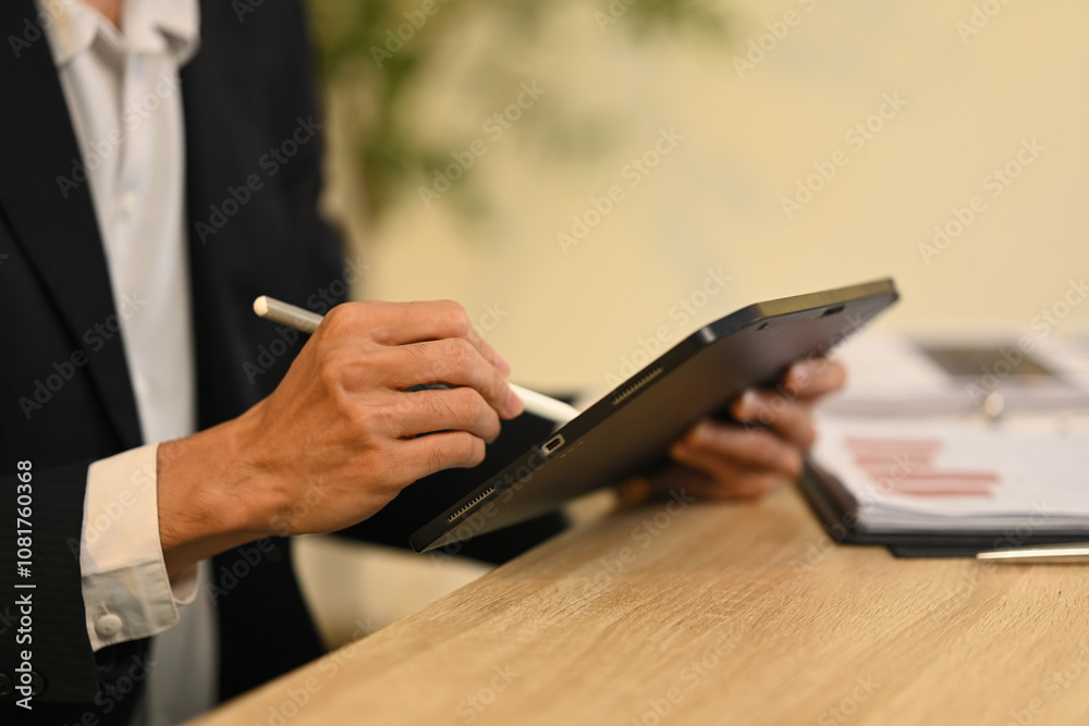 © Prathankarnpap - Cropped shot businessman taking notes digitally with stylus on digital tablet