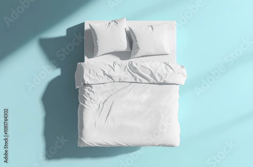 A white bed with two pillows and a white comforter