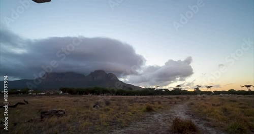 Motion Time Lapse at sunset with a view of Table Mountain from a park in the suburbs with people on an evening walk. Moving clouds and a path in the foreground. photo