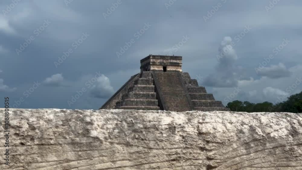 Handheld booming up shot over a stone wall to reveal the ancient Mayan pyramid El Castillo in Chichen Itza, Mexico. 4K Handheld booming up shot over a stone wall to reveal the ancient Mayan pyramid El Castillo in Chichen Itza, Mexico. 4K