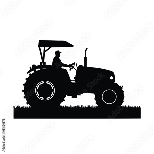 A man is driving a tractor. The tractor is black and has a large tire. The man is wearing a hat