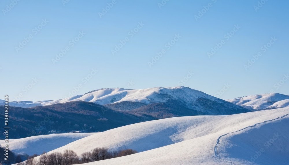 Snow-covered hills under a clear winter sky Snow-covered hills under a clear winter sky