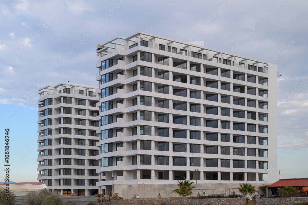 Modern residential buildings rise against a cloudy sky in an urban landscape near the coast Modern residential buildings rise against a cloudy sky in an urban landscape near the coast