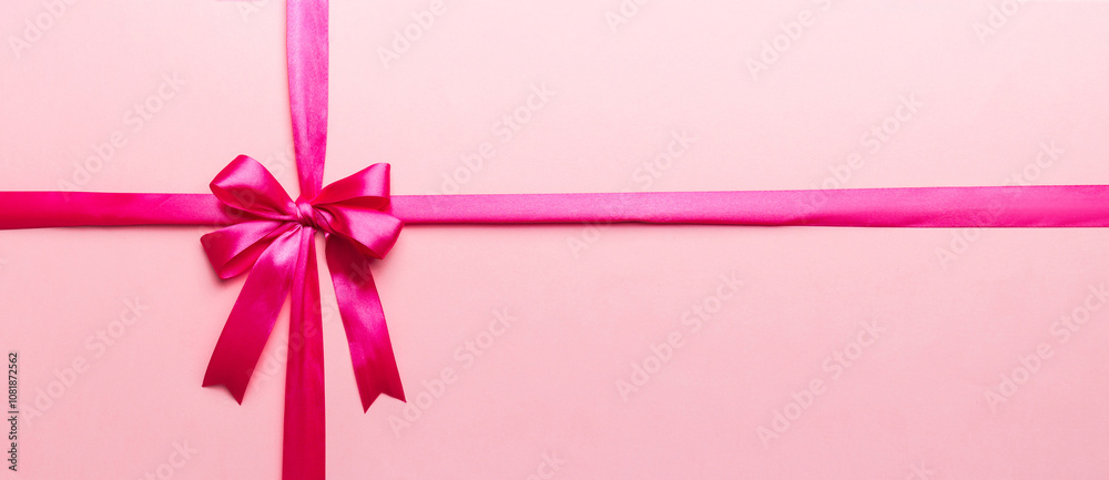 Top view of purple ribbon rolled and pink bow isolated on colored background. Flat lay with copy space Top view of purple ribbon rolled and pink bow isolated on colored background. Flat lay with copy space