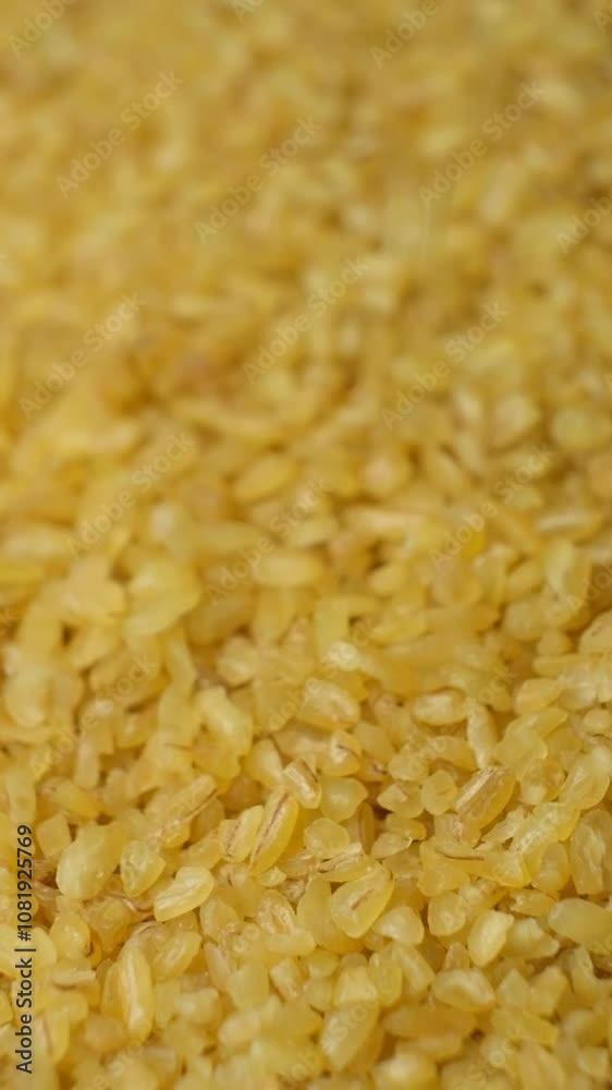 Uncooked bulgur cracked wheat pour. macro vertical slow motion Uncooked bulgur cracked wheat pour. macro vertical slow motion