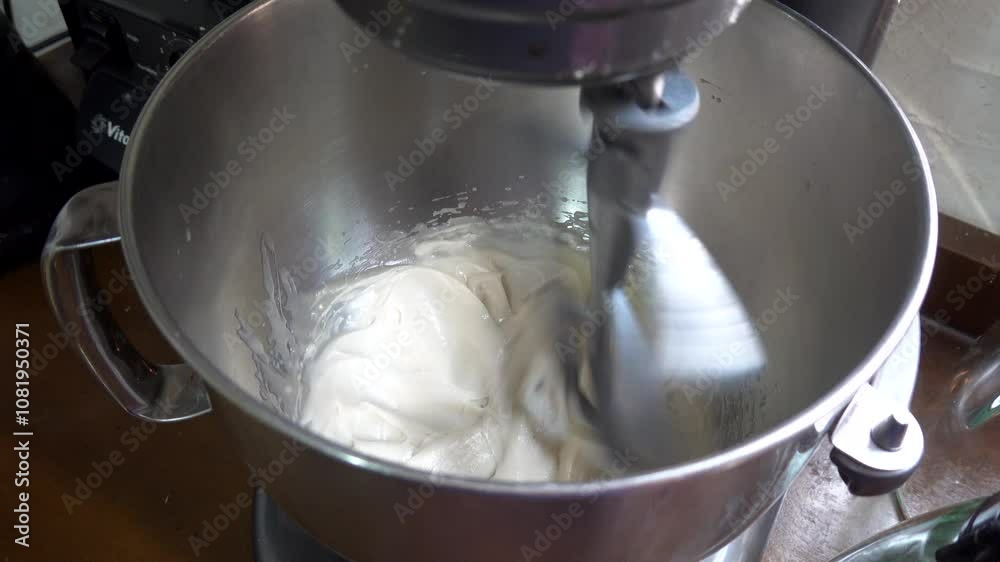 Stand mixer whisking ingredients in a stainless steel bowl on a kitchen countertop, creating a delicious batter or dough Stand mixer whisking ingredients in a stainless steel bowl on a kitchen countertop, creating a delicious batter or dough