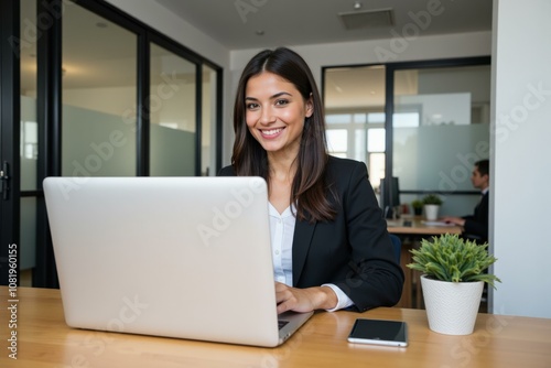 Professional Woman Working on Laptop in Modern Office Setting, Ideal for Business and Technology Websites