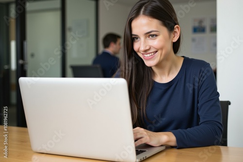 Smiling Young Woman Working on Laptop in Modern Office Setting, Ideal for Business and Technology Concepts