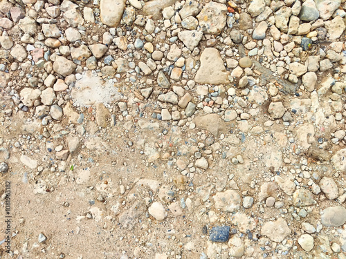 A rough gravel surface filled with various stones and pebbles provides an excellent backdrop for text and design elements