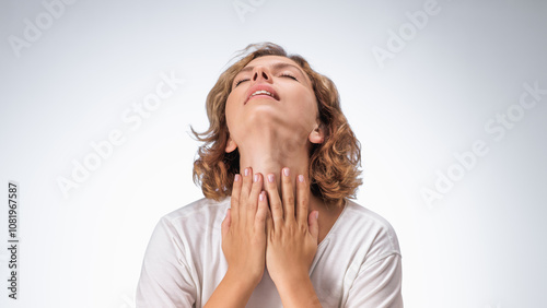 Valokuva High-quality image of a woman holding her throat in pain, head tilted back against a plain background