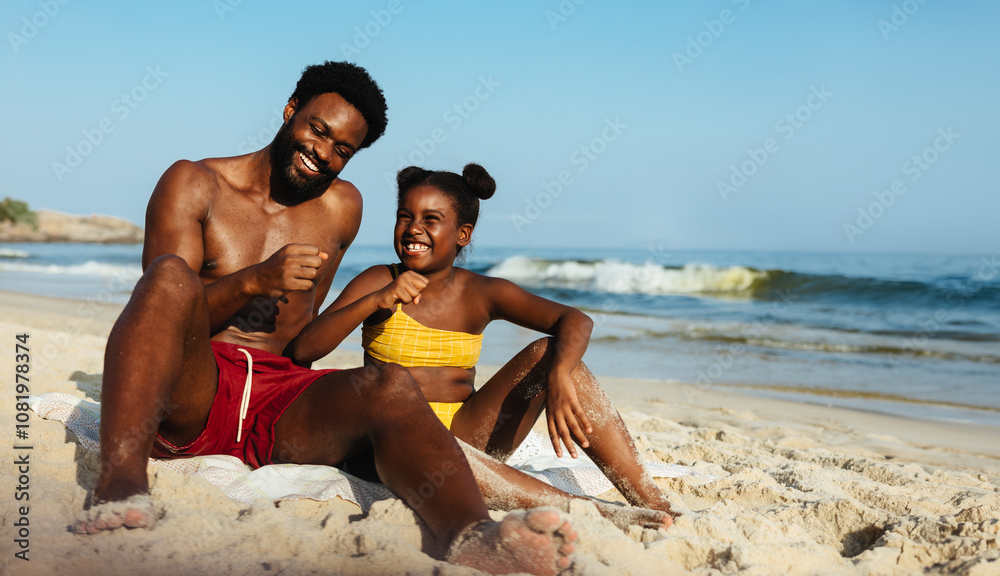 Fototapeta premium Father and daughter playing in the sand on a sunny beach