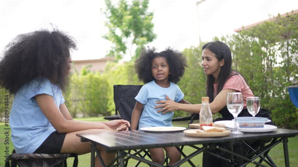 Mother and daughter are grill barbeques at backyard. Lifestyle, weekend activity. Mother and daughter are grill barbeques at backyard. Lifestyle, weekend activity.