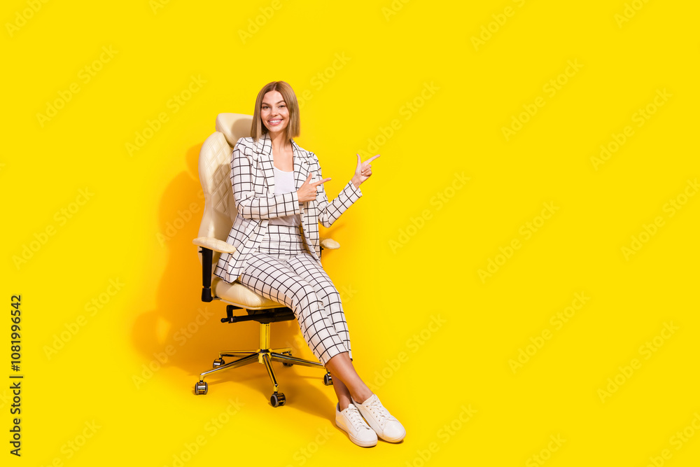 Charming young businesswoman in stylish checkered suit posing confidently against a vibrant yellow background Charming young businesswoman in stylish checkered suit posing confidently against a vibrant yellow background
