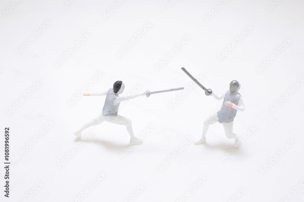 Two Miniature Fencers Engaging in a Sword Fight Two Miniature Fencers Engaging in a Sword Fight