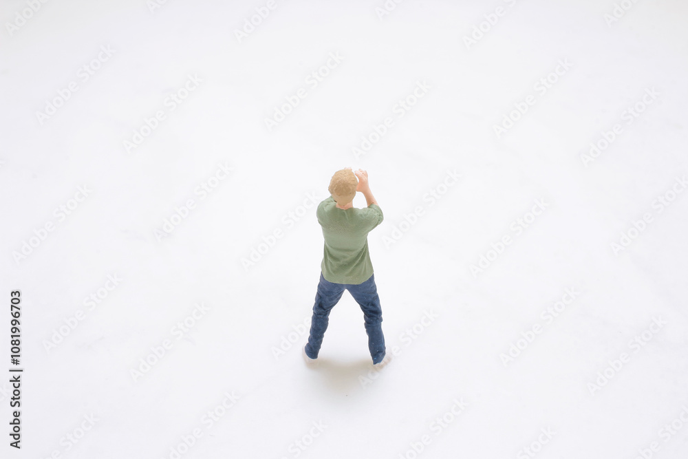 Miniature Figure of Man Standing on White Background Miniature Figure of Man Standing on White Background