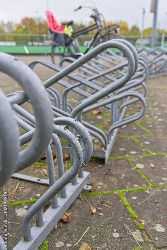 Bicycle rack at a hockey club, containing a parked men's bike with double rod and a child seat in the back. Bicycle rack at a hockey club, containing a parked men's bike with double rod and a child seat in the back.