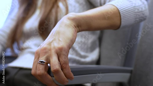 Woman puts hand on an armrest during sitting in airplane seat, close-up