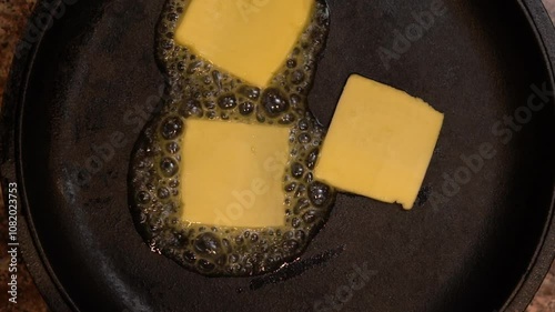 Melting and stirring butter in a cast iron pan creates a rich, golden liquid, enhancing flavors for various dishes