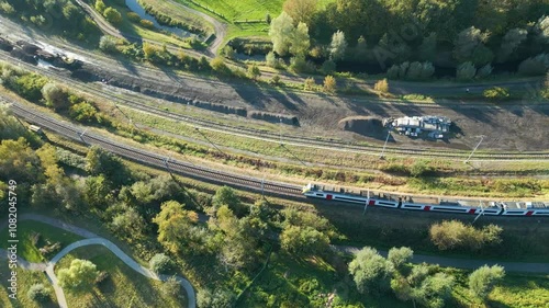 train driving along railway track public transport network belgium efficiency belgian system aerial drone panning shot view footage 