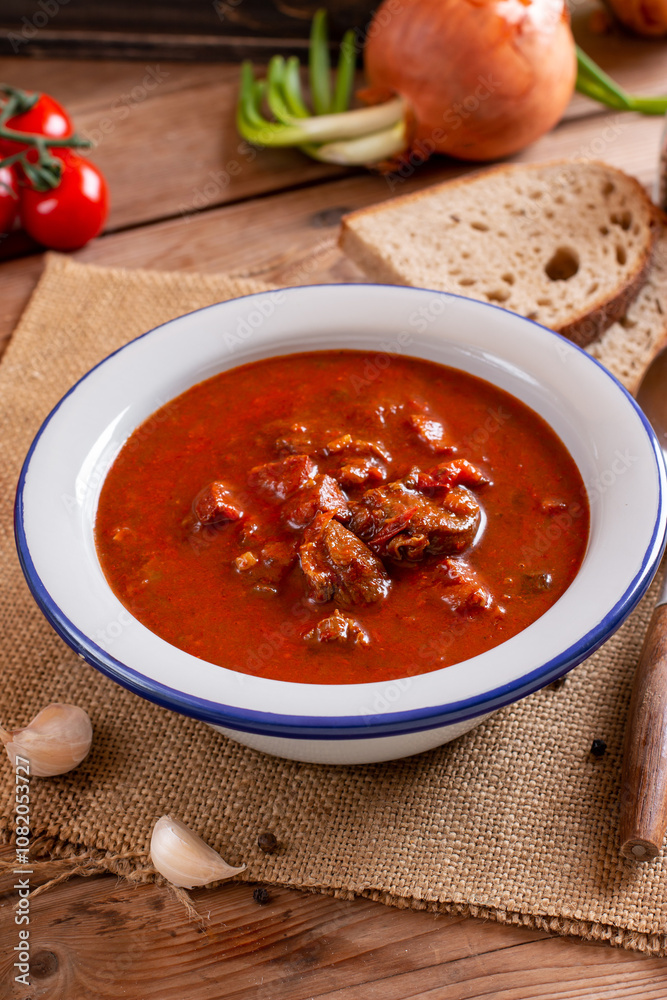 Beef goulash, soup and a stew, made of beef chuck steak and plenty of paprika on table. Hungarian traditional meal. Beef goulash, soup and a stew, made of beef chuck steak and plenty of paprika on table. Hungarian traditional meal.