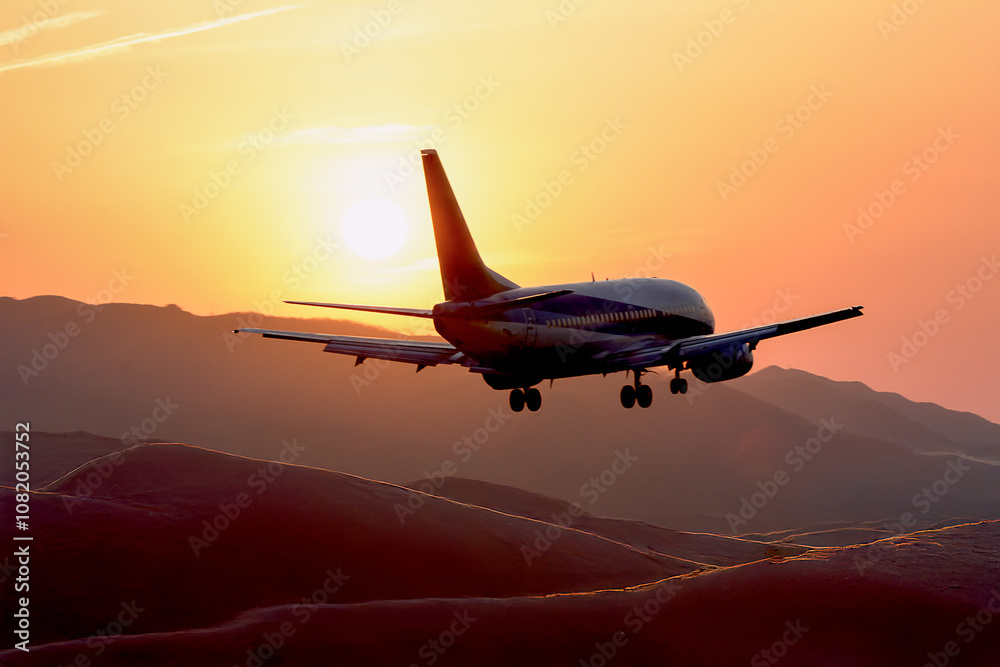 Fototapeta premium 夕焼けの空から太陽、山間部の空を飛ぶ飛行機