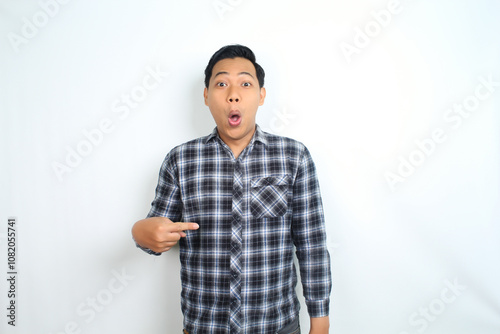 shocked asian man pointing hand with surprised funny expression isolated on white