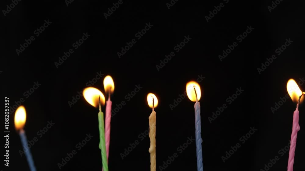 close up on colorful birthday candle on a dark background.
close up on colorful birthday candle on a dark background.