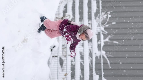 Little girl wearing a cozy winter outfit, happily exploring deep snow. The pure white snow surrounds her, creating a dreamy winter scene full of childhood wonder