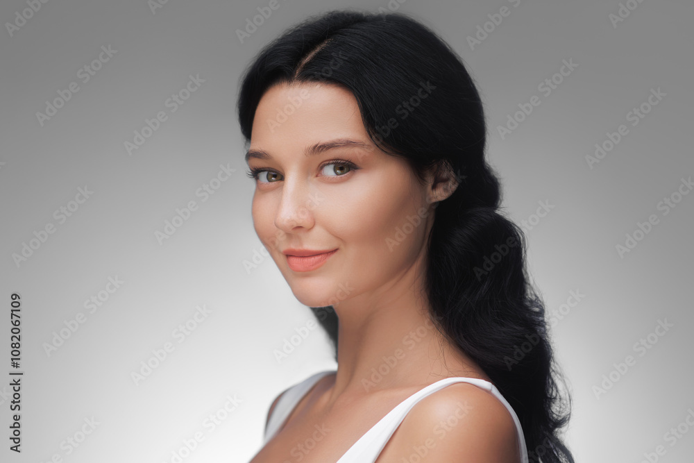An elegant woman with dark hair and radiant skin poses in a side profile, exuding natural beauty and grace against a soft gradient background. Perfect for skincare, wellness, and beauty advertising