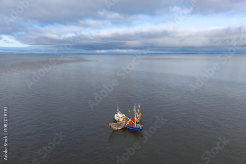 Photos Aerial of fishing ship, boat trawling nets with gulls at Wadden sea