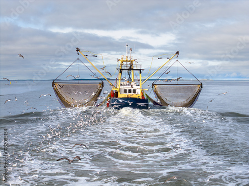 Aerial of fishing ship, boat trawling nets with gulls at Wadden sea